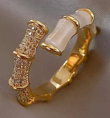 Gold and white hoop earrings on a satin surface