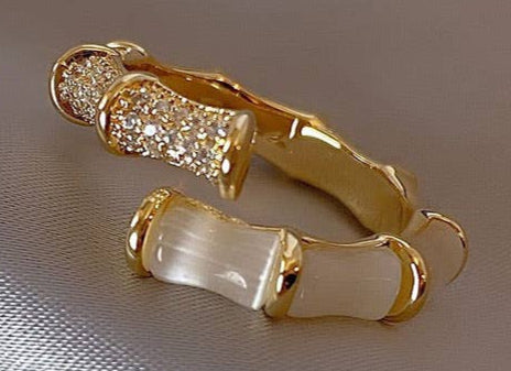 Gold hoop earrings with pearl accents on a beige fabric background